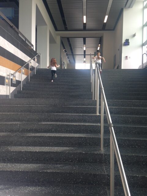 Children running up stairs at a science center
