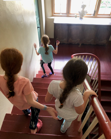 children going down a staircase in a historic home during a homeschool field trip